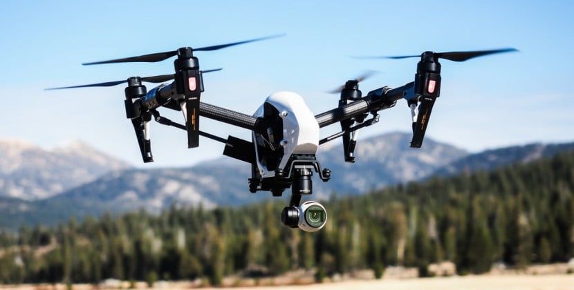 drone flying over woodland, mountains in background