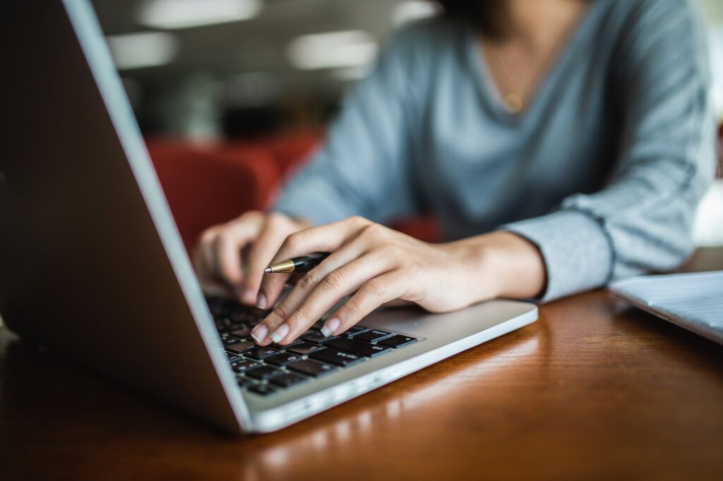 women typing on laptop researching a career in television
