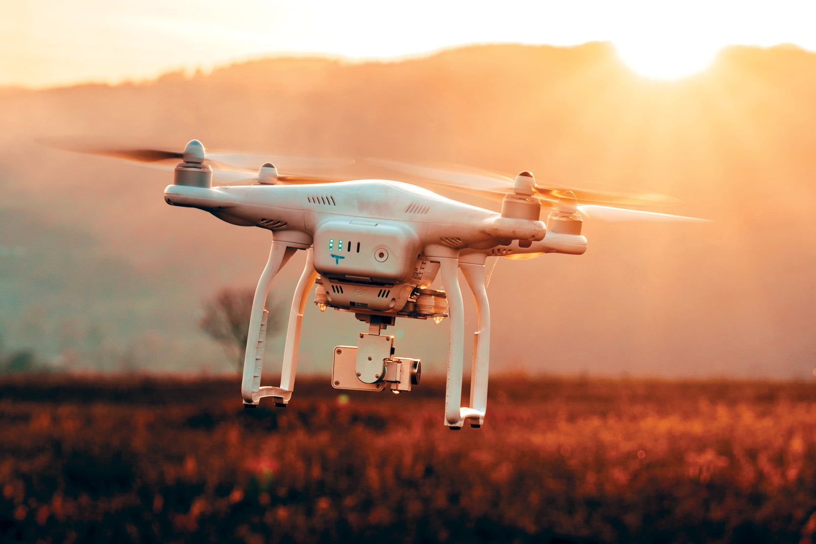 drone flying over meadow during sunset